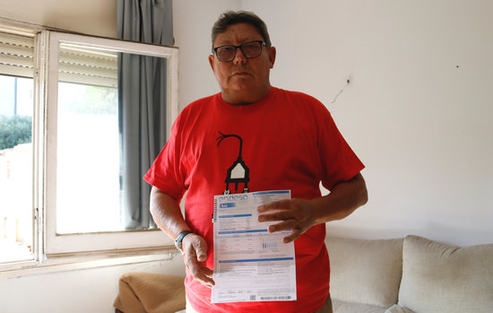 José Luis Jacas holds up one of his unpaid bills (Blanca Blay/ACN)